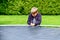 The boy assembles a new trampoline and stretches the springs to jump