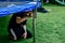 The boy assembles a new trampoline and stretches the springs to jump