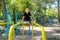 The boy athlete performs an exercise on the gymnastic bars, while he stretched his legs forward and twisted his face from the fact