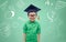 Boy in bachelor hat and eyeglasses over blackboard