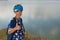 A boy with a backpack on a hike, against a background of a pond, shows thumb up, pleasure