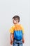 Boy with a backpack stands back on a white background