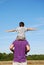 Boy balancing on his father\'s shoulders