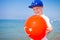 Boy with balloon Turkey flag on blue sea beach
