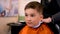 Boy in the barber shop. Close up of teenage boy being trimmed with professional electric clipper machine in barbershop