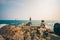 Boy on Beach at Sunset. The guy is standing alone on the rocks, on the beach