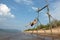 A boy on the beach swinging on a swing.Summer sunny day