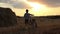 Boy with the bicycle in the field at sunset, near haystacks