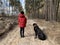 Boy with a big dog for a walk in the woods. A teenager walks with a black dog in the park. Cane Corso on a leash