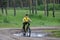 A boy on a bike rides a puddle and laughs in forest