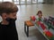 A boy in black clothes and a girl near a table with a paper model - a model of a city or district. School assignment to