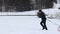 Boy in black winter clothes pulls a sledge to the top of the slope. Enjoying young age. Winter fun. Fooling around in the snow. Fu