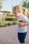 Boy with blond hair ponytail playing with orange