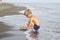 boy with blond hair in swimming glasses playing on the beach in