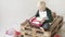 Boy blond sits on a wooden pallet with a gift in his hands.