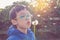 Boy blowing away flower in garden