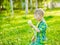 Boy blowing dandelion on green grass