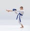 Boy with blue belt and overlays on the hands is beating kicking