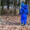 A boy in blue clothes walks to a squirrel