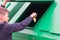 A boy in a blue jumper throws an Apple stub into a green dumpster