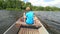 Boy in blue with life jackets at legs floats on vessel boat and hard woarking. Young man in metal  boat sail