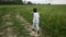 Boy in blue pants and a white jacket in a hood runs along the road