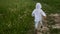 Boy in blue pants and a white jacket in a hood runs along the road