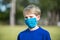 Boy in blue shirt wearing homemade face mask for protection during covid19 pandemic