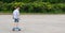 Boy on a blue sports skateboard, rolling on a stone square, there is a place for the inscription