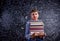 Boy with books against big blackboard with mathematical symbols