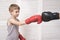 Boy in boxing gloves fights with a man`s hand in a glove.