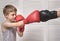 Boy in boxing gloves fights with a man`s hand in a glove.