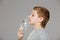 Boy breathing from inhalator mask releasing smoke