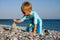 Boy building stone stack on beach