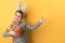 Boy with bunny ears holding a basket with painted eggs