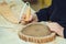 Boy burn out numbers with soldering iron on wooden disc. Kid makes wooden clock in the workshop