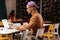 Boy in cap sitting in cafe and filling yearly report.