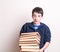 Boy carrying a heavy load of books