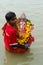 A boy carrying the idol of Hindu God Ganesha