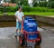 A boy carrying large cans of milk in a trolly; countryside life