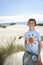 Boy Carrying Plastic Bag Filled With Garbage On Beach