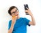 A boy in casual clothes holding donut and cellphone using technologydo selfie