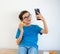 A boy in casual clothes holding donut and cellphone using technologydo selfie