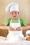 Boy with chef hat preparing the dough