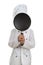 Boy chef hiding his face behind the black frying pan