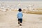 Boy child chasing seagulls at beach