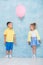 Boy child gives a balloon to a girl. Signs of attention, sympathy and courtship.