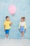 Boy child gives a balloon to a girl. Signs of attention, sympathy and courtship.