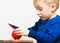 Boy child kid preschooler with knife cutting fruit apple at home