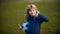 Boy child playing football on football field. Kid playing soccer show thumbs up success sign. Boy holding soccer ball